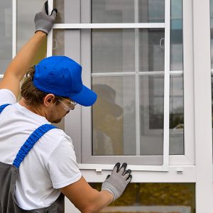 Worker installing window screen