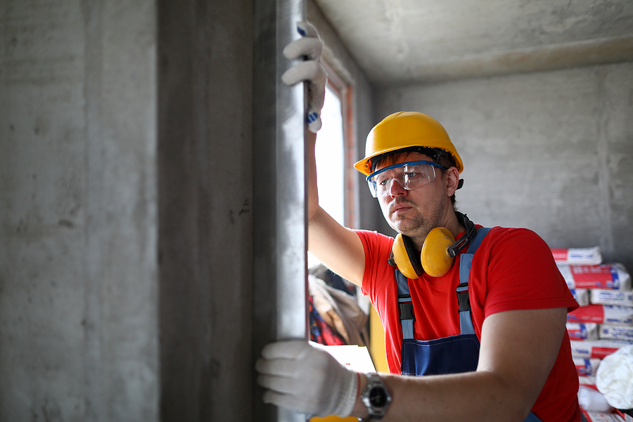 What wind speed are windows rated for in Florida - Builder in helmet measures level wall at window. Level is used to install door structures and windows. Measuring device used to control installation materials and structures in vertical planes