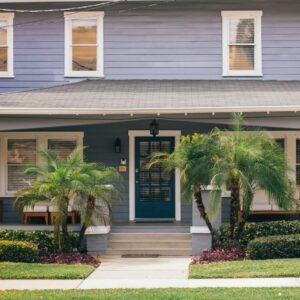 a blue house with palm trees in front of it